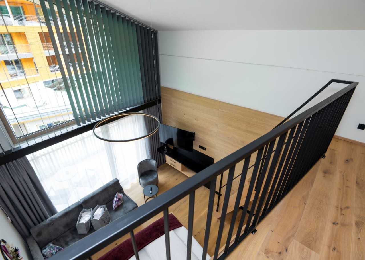 Blick von der oberen Etage einer Suite auf den gemütlichen Wohnbereich mit großen Fenstern